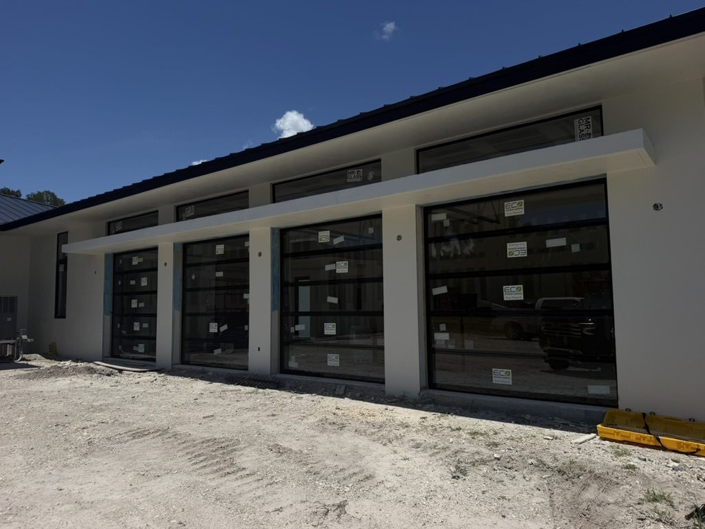 Full-view aluminum and glass garage doors on a new construction home