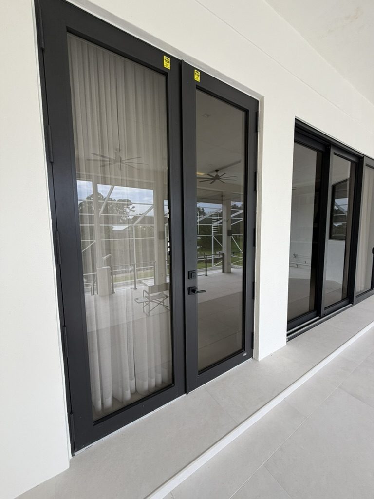 Impact French doors and sliding glass door opening to a screened patio